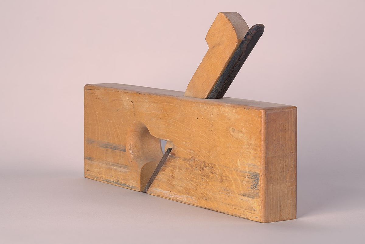 Traditioneller Holzhobel mit Keil vor hellem Hintergrund